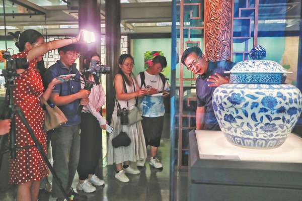 Ο Γουάνγκ Λαν, σύμβουλος στο Jingdezhen Imperial Kiln Institute, παρουσιάζει στους επισκέπτες ένα μπλε και λευκό πορσελάνινο βάζο του 15ου αιώνα, διακοσμημένο με σχέδια από χρυσάνθεμα. (CHINA DAILY/JIANG DONG)