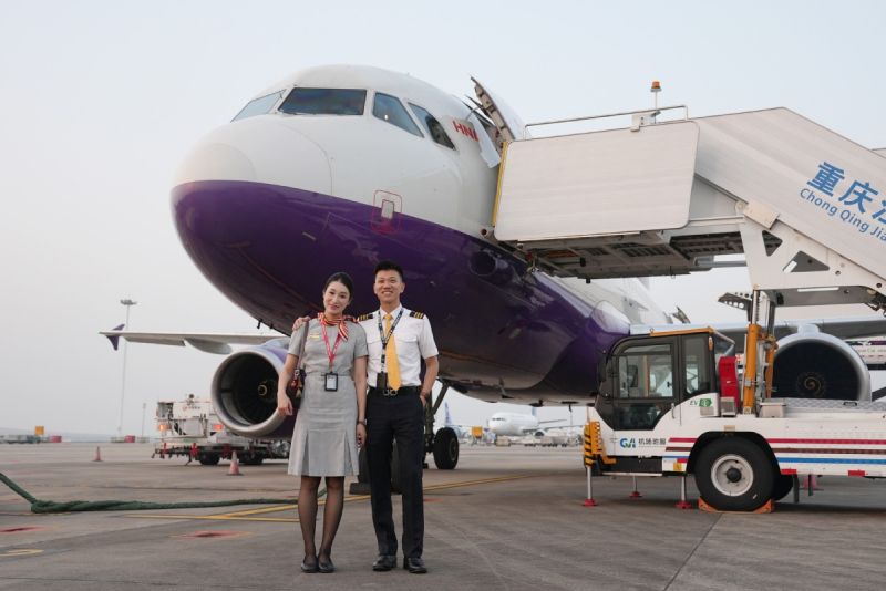 Ο Γουάνγκ Σαοπένγκ και η σύζυγός του Τσιάο Γιου ποζάρουν μπροστά από το αεροπλάνο. (Φωτογραφία/China Daily)