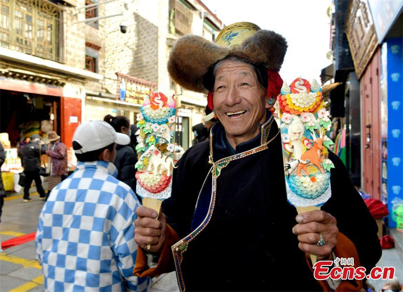 Τεχνίτης παρουσιάζει γλυπτά με βούτυρο για τον εορτασμό του Λοσάρ, ή αλλιώς το Θιβετιανό Νέο Έτος, στη Λάσα, στην αυτόνομη περιοχή Σιζάνγκ της νοτιοδυτικής Κίνας, στις 30 Ιανουαρίου, 2024. (Φωτογραφία: China News Service / Li Lin)