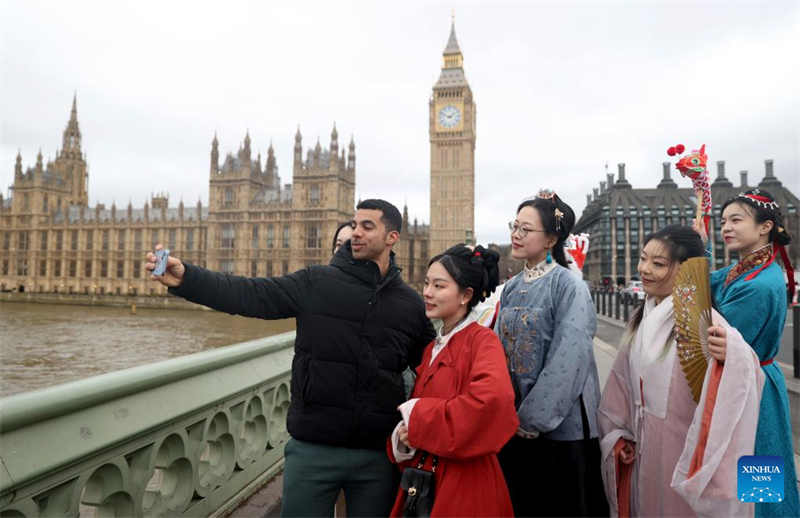 Ένας άνδρας βγάζει σέλφι με λάτρεις του Χανφού μπροστά από το Κοινοβούλιο στο Λονδίνο, της Βρετανίας, στις 25 Φεβρουαρίου. (Φωτογραφία / Xinhua)