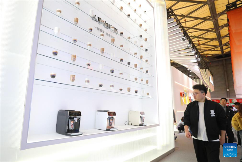Ένας επισκέπτης περπατά μπροστά από τον τοίχο προβολής των προϊόντων καφετιέρας της εταιρίας Philips κατά τη διάρκεια της Παγκόσμιας Έκθεσης Συσκευών & Ηλεκτρονικών Ειδών για το 2024,  στην Σανγκάη, στις 14 Μαρτίου του 2024. (Φωτογραφία / Xinhua)