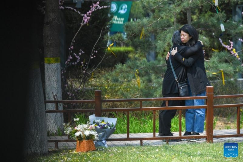Άνθρωποι αγκαλιάζονται μετά την τοποθέτηση λουλουδιών για να θρηνήσουν τους αποθανόντες σε ένα νεκροταφείο στο Πεκίνο, στις 2 Απριλίου του 2024.