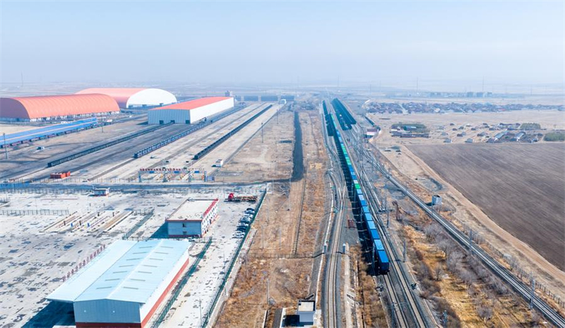 Μια αεροφωτογραφία που τραβήχτηκε στις 25 Μαρτίου δείχνει ένα εμπορευματικό τρένο Κίνας-Ευρώπης να περνάει από τον διεθνή σιδηροδρομικό κόμβο εφοδιασμού Τζισουμού στο Ουλανκάμπ της Αυτόνομης Περιφέρειας της Εσωτερικής Μογγολίας. (Φωτογραφία / Xinhua)