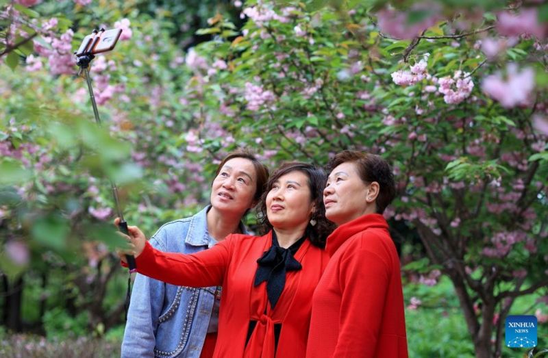 Άνθρωποι βγάζουν σέλφι με ανθισμένα λουλούδια σε ένα σύγχρονο αγροτικό βιομηχανικό πάρκο στην πόλη Τάϊτζόου, της επαρχία Τζιανγκσού, στην ανατολική Κίνα, στις 17 Απριλίου του 2024.