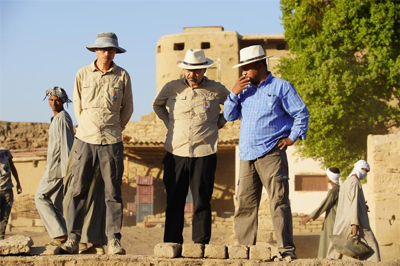  Κινέζοι αρχαιολόγοι επικοινωνούν με έναν Αιγύπτιο αρχαιολόγο στον χώρο ανασκαφής του ναού Μόντου στην πόλη Λούξορ της Αιγύπτου.  (Φωτογραφία / Xinhua)