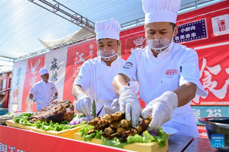  Σεφ ετοιμάζουν πιάτα κατά τη διάρκεια του διαγωνισμού μαγειρικής αρνιού στην κομητεία Γιουμίν του νομού Τατσένγκ, της αυτόνομης περιοχής των Ουιγούρων στην επαρχία Σιντζιάνγκ,  στις 2 Ιουνίου. (Φωτογραφία / Xinhua)