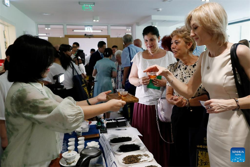 Άνθρωποι δοκιμάζουν κινέζικο τσάι κατά τη διάρκεια εκδήλωσης για την προώθηση του τουρισμού και του πολιτισμού του τσαγιού της επαρχίας Γκουεϊτζόου στη Ρουμανία, στις 26 Ιουνίου. (Φωτογραφία / Xinhua)