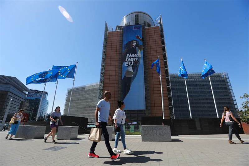 Οι άνθρωποι περπατούν μπροστά από το κτίριο της Ευρωπαϊκής Επιτροπής στις Βρυξέλλες, Βέλγιο, 19 Ιουνίου 2022. Ένα κύμα καύσωνα πλήττει πρόσφατα το Βέλγιο, με τη θερμοκρασία την Τρίτη να φτάνει τους 39 ή 40 βαθμούς Κελσίου. 19/6/2022. Φωτογραφία: Xinhua