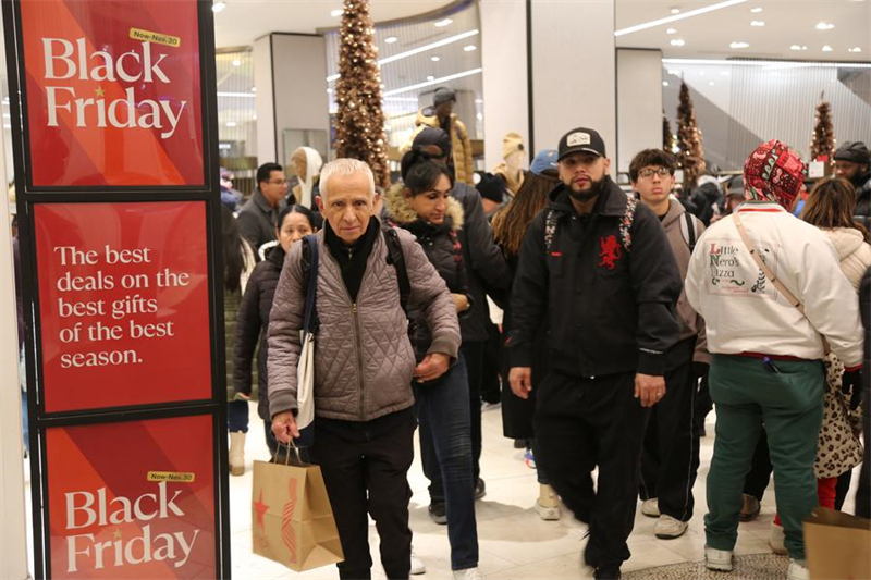 Καταναλωτές περπατούν μπροστά από πινακίδες προσφορών της Black Friday σε κατάστημα στο Μανχάταν, Νέα Υόρκη, Ηνωμένες Πολιτείες, στις 29 Νοεμβρίου 2024. (Φωτογραφία / Xinhua)