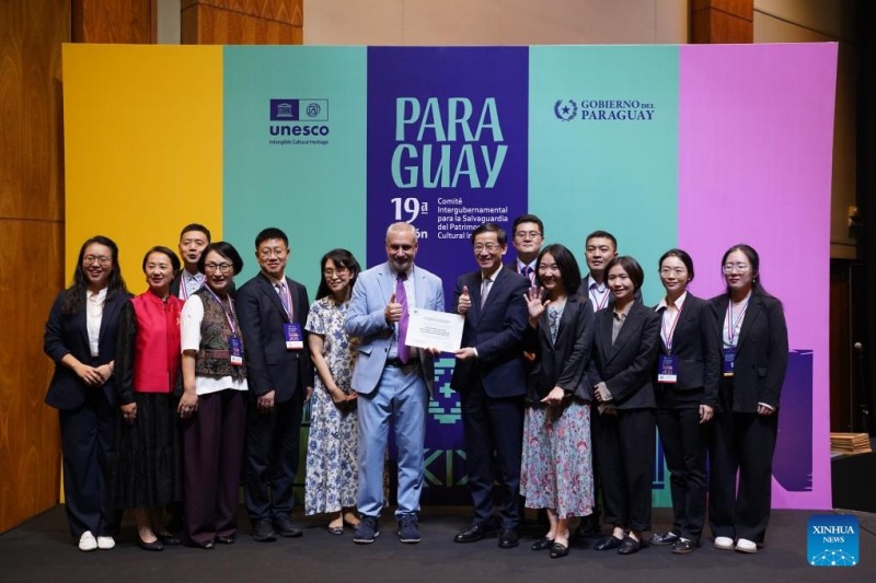 Κινέζοι αντιπρόσωποι ποζάρουν για φωτογραφία μετά την παραλαβή του πιστοποιητικού αναγνώρισης κατά τη διάρκεια της 19ης συνεδρίασης της Διακυβερνητικής Επιτροπής για την Προστασία της Άυλης Πολιτιστικής Κληρονομιάς στην Ασουνσιόν, Παραγουάη, 5/12/ 2024.