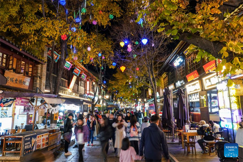 Τουρίστες περπατούν σε εμπορικό δρόμο τη νύχτα στην πόλη Κουνμίνγκ, στην επαρχία Γιουννάν της νοτιοδυτικής Κίνας, στις 6 Δεκεμβρίου 2024. (Φωτογραφία / Xinhua)