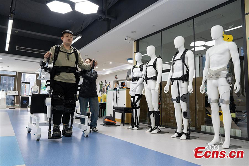 Ένας ανάπηρος άνδρας σηκώνεται αργά με τη βοήθεια ρομποτικού εξωσκελετού στην πόλη Χανγκτζόου, επαρχία Τζετζιάνγκ, 13 Μαρτίου 2025. Φωτογραφία / China News Service