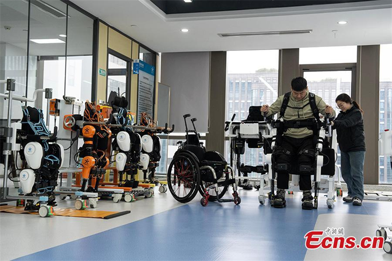 Ένας ανάπηρος άνδρας σηκώνεται αργά με τη βοήθεια ρομποτικού εξωσκελετού στην πόλη Χανγκτζόου, επαρχία Τζετζιάνγκ, 13 Μαρτίου 2025. Φωτογραφία / China News Service