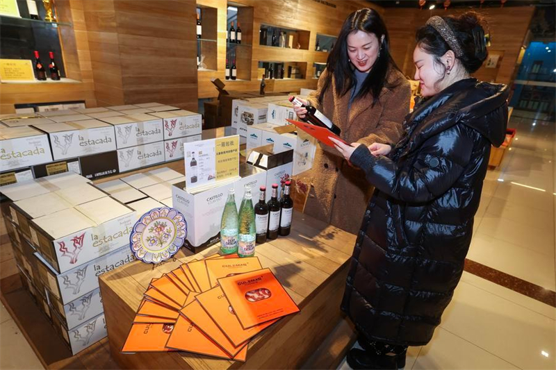 Πελάτες ενημερώνονται για το ισπανικό ζαμπόν και το κόκκινο κρασί σε κατάστημα πώλησης ισπανικών εισαγόμενων προϊόντων στην πόλη Γιγού της επαρχίας Τζετζιάνγκ, στις 30 Ιανουαρίου του 2026. (Φωτογραφία / Xinhua)
