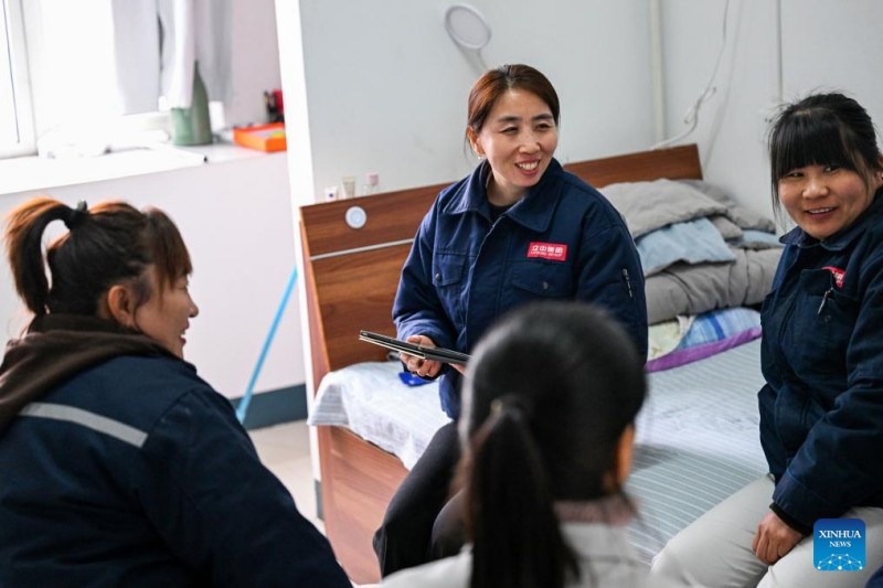 Η Γκουό Χονγκτζίνγκ (δεύτερη από αριστερά) ζητά προτάσεις από συναδέλφους της σε κοιτώνα της Tianjin Lizhong Wheel Co., Ltd., στην πόλη Τιαντζίν, στις 25 Φεβρουαρίου του 2026.